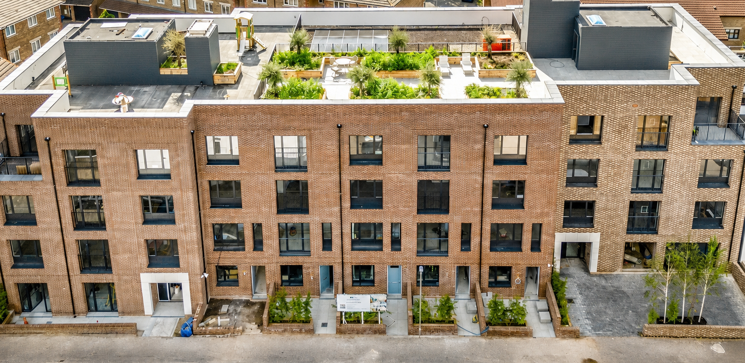 Aerial view of a modern brick apartment development with green rooftop garden completed by Blair Contracts